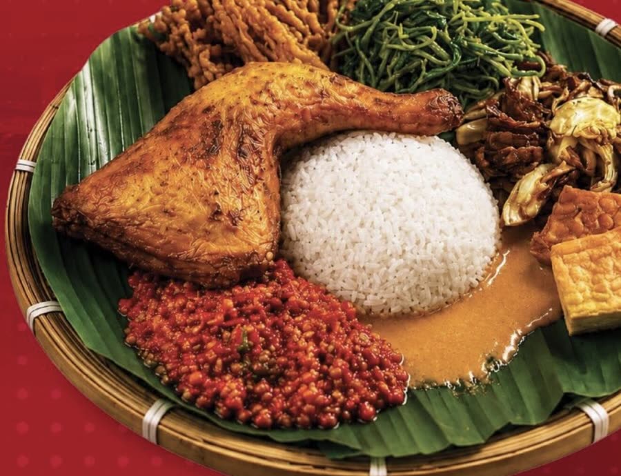 Ayam Gepuk Masrio signature set: fried chicken, rice, sambal and sides on a banana leaf